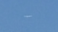 Oval shaped UFO shining or glowing in the sky image 1002